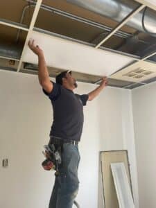 TGEP technician installing LED lighting and Lutron smart switches in a modern medical office condo"